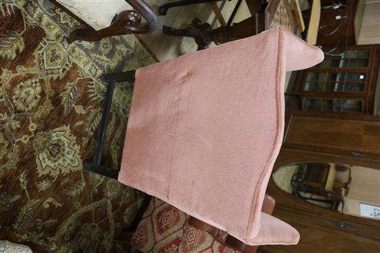 A George III mahogany framed pink dralon upholstered wing armchair